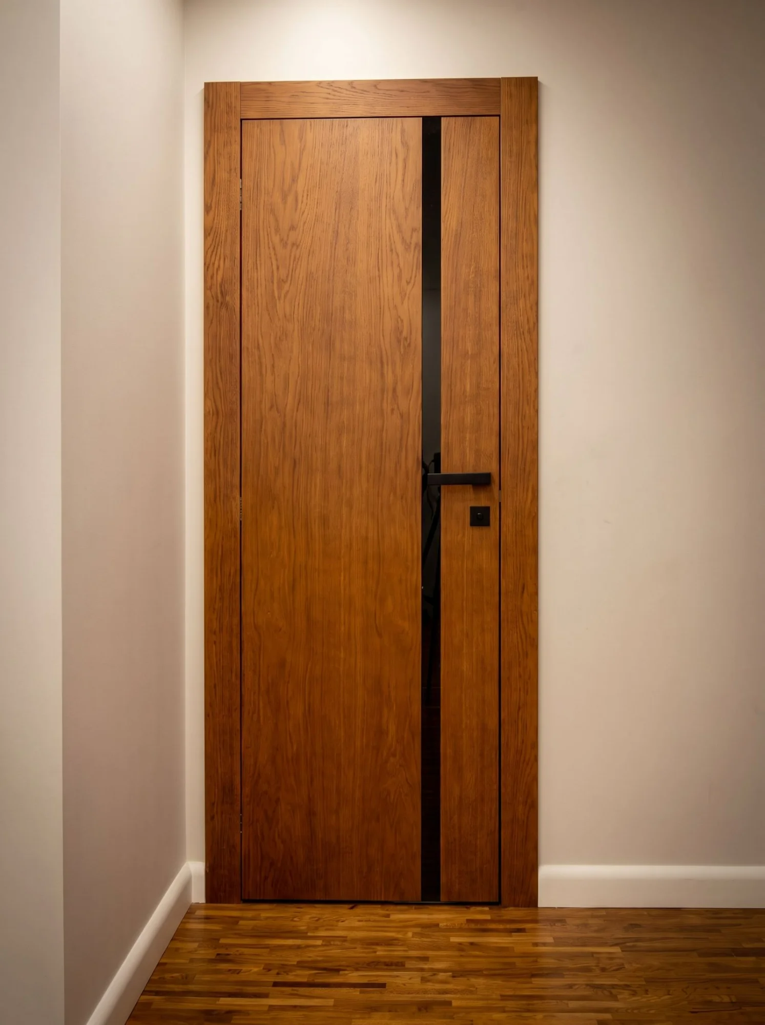 Classical white rebateless door with a raised panel, decorative moulding and geometric wallpaper, nickel handle — a Creadoor project