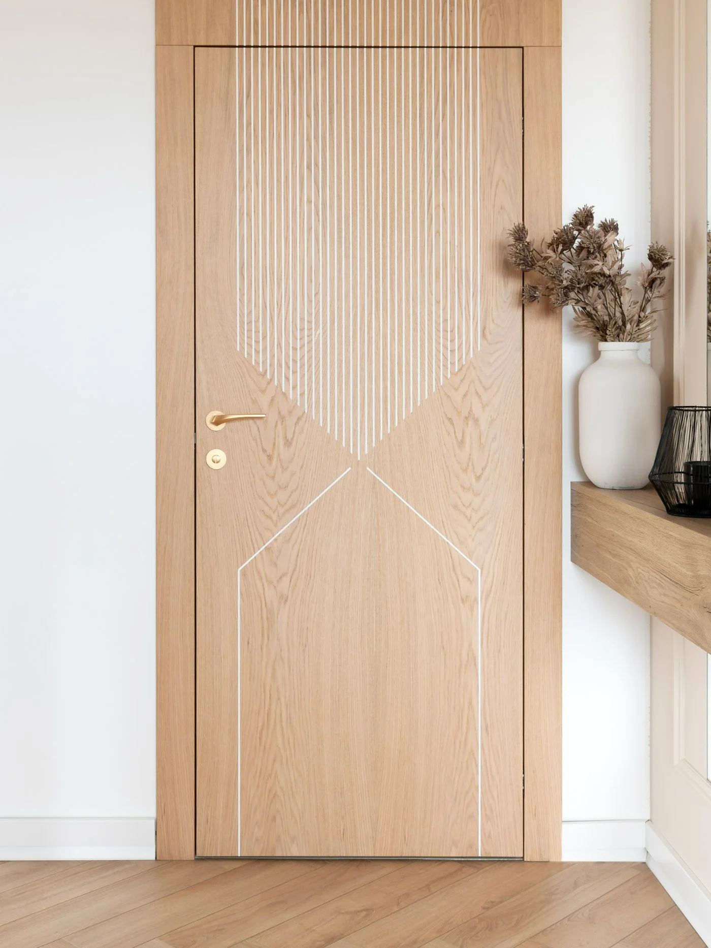 Rebateless door from the Geometria collection, pattern G2 — a rhythm of vertical lines converging in a rhombus, natural oak