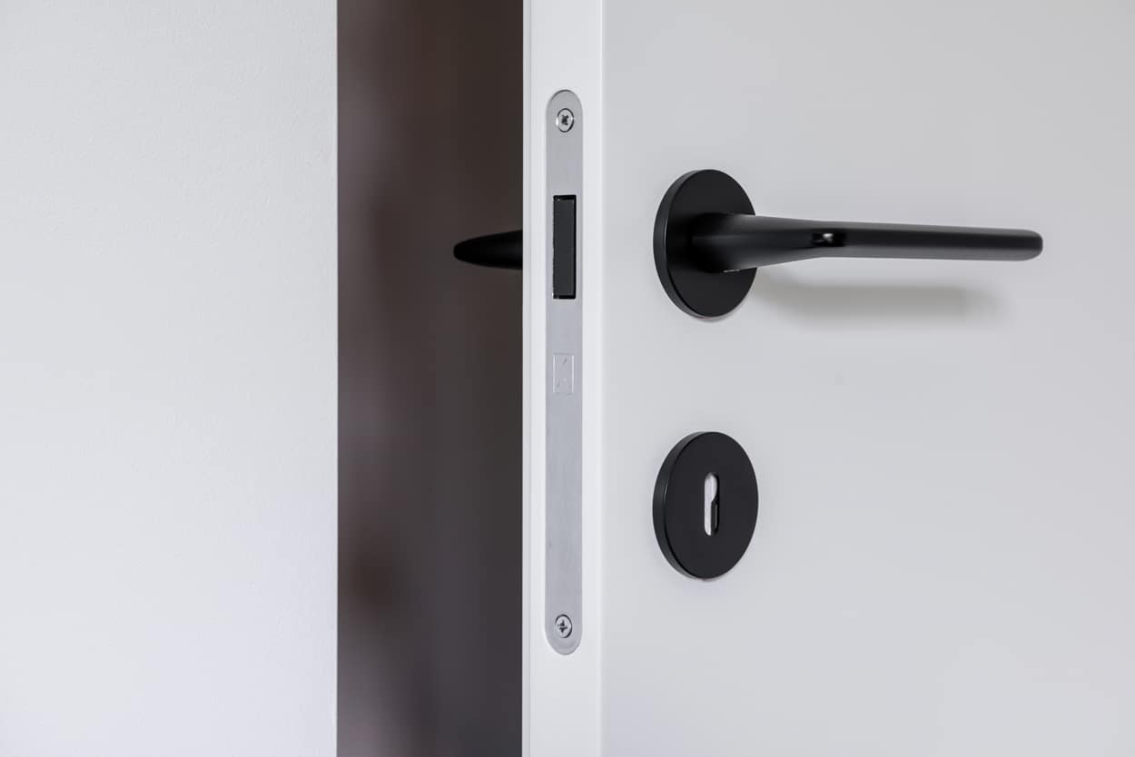 Zbliżenie na minimalistyczną klamkę w kolorze czarnym