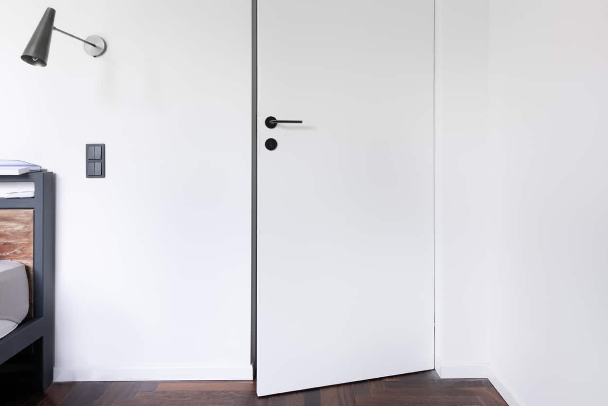 Białe nowoczesne drzwi z minimalistyczną klamką